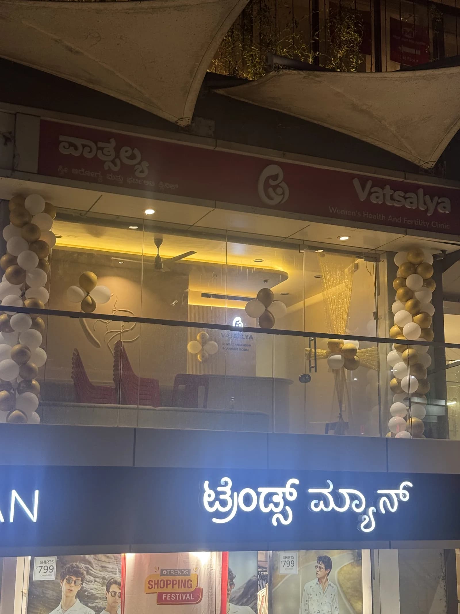 The Vatsalya clinic front in the evening, with the signboard and the reception lit from inside
